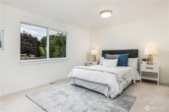 Primary bedroom looks over the private, beautifully landscaped backyard.