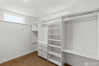 Large walk in closet with custom shelving/storage