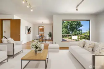 Living room with view out to deck and dining area - kitchen beyond. Virtually staged to show potential.