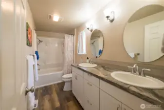 Primary bath with dual sink vanity and a tub/shower combo.