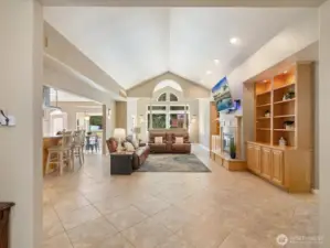 The main living area features a vaulted ceiling, custom built-ins, and a gas stubbed and wood fireplace. Beyond, find the Sun Room, or what the owner's call the "Christmas Tree Room." Fireplace has gas stubbed- sellers have never used it that way. But can be if desired very easily.