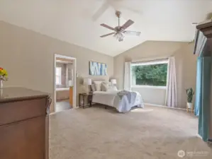 The expansive primary suite features vaulted ceilings, abundant natural light, and a stunning en-suite bathroom.