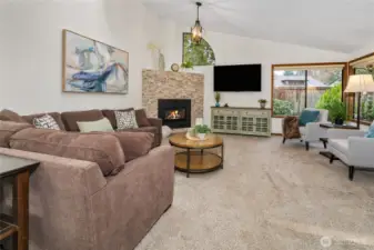 Vaulted ceilings in large living room with newer, stacked stone fireplace surround.