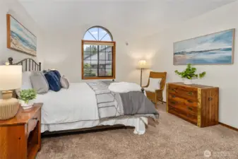 Main floor en suite bedroom looking out the arched window.