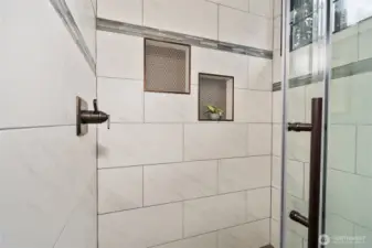 Close up view of the tiled, walk-in shower in the primary bathroom.