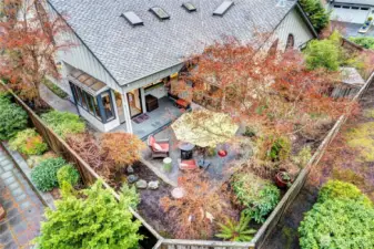 A wider drone shot of the rear yard, patio and deck.