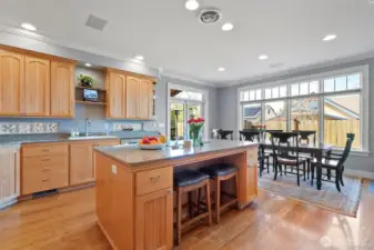 A spacious kitchen designed to seamlessly integrate the main dining area alongside inviting casual countertop seating.