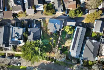 House sits on paved alley with large yard in front.