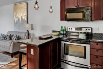 An eat-in kitchen with granite bar opens to the living room