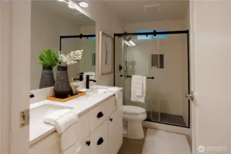 Remodeled bathroom with tiled shower, flooring and updated vanity and fixtures.