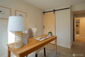 Lower level bedroom staged as an office. Sliding barn door and private bathroom.