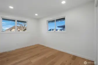 The remodeled second bedroom with bright lighting is spacious and faces the front of the home.