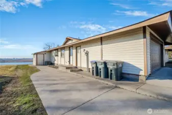 The sidewalk on the side of the home leads to the garage man door, laundry/utility room door, and the door to the storage unit. The sidewalk curves on around to the back of the house where you have an amazing view of the lake!