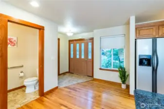 Convenient main-floor entry with nearby powder room creates a functional layout for guests and everyday living. Hardwood floors and large windows bring warmth and natural light to the space.