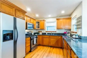Functional kitchen with stainless steel appliances, ample cabinet storage & durable countertops designed for everyday use. Window over the sink brings in natural light and views of the surrounding greenery.