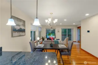 Open main-floor layout connects dining, living, and kitchen areas, creating a comfortable space for daily life and casual entertaining. Large windows bring in light and frame peaceful wooded surroundings.