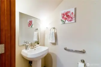 Convenient main-floor powder room with pedestal sink is ideal for guests. Located just off the main living space for easy access.
