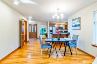 Dedicated dining space sits within the open floor plan and flows easily toward the kitchen and entryway. Hardwood floors and large windows keep the space bright and welcoming.