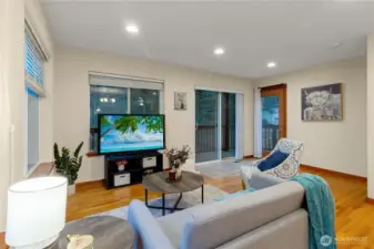 Bright living room opens directly to the back deck through sliding glass doors, creating an easy indoor-outdoor flow for relaxing or entertaining.