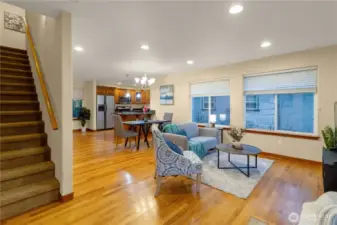 View from the living area toward the kitchen with the staircase tucked toward the back of the home, providing convenient access to the upper-level bedrooms while keeping the main living space open.