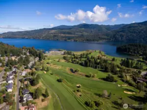 Aerial view of Sudden Valley featuring the golf course, marina, and Lake Whatcom shoreline surrounded by forested hills.