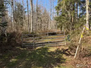 Gated entry to property. Survey marker for property to right to the gate.