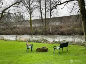 Residents enjoy the back yard firepit on the river's edge.
