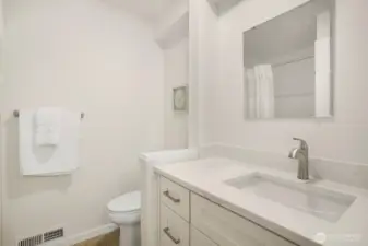 The 3/4 bathroom on the lower level has a beautiful new built-in vanity with Quartz counter, new faucet, tile floor and easy to maintenance fiberglass walk-in shower.
