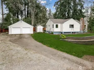 A spacious two-car garage with attic storage and a long gated driveway provide ample room for RV and boat parking.