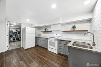 Basement ADU kitchen with access to large dry storage and utilities room.