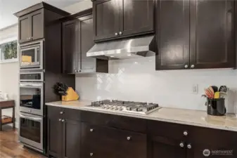 Five-burner gas cook top, double ovens and microwave just to the left - well designed space