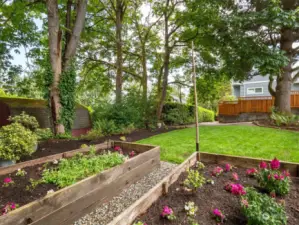 Raised garden beds and a paver patio create a natural backdrop at the north end of the property.