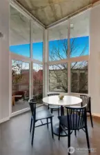 Warm western light pours through the floor-to-ceiling windows, complemented by a private deck with tree-lined and Space Needle views.