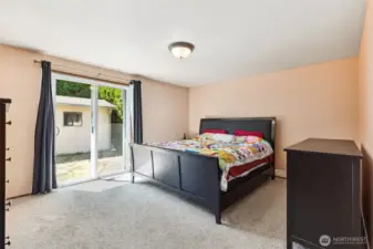 Spacious primary suite with a convenient slider to the back yard and en suite bathroom.