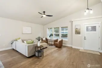 Cozy living space anchored by large windows and natural light