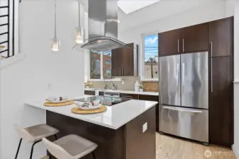 Gorgeous kitchen features quartz counters and modern stainless steel appliances.  The kitchen island allows for additional dining space.