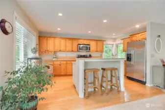 Wonderful island kitchen with hardwood floors, quartz counters, stainless steel appliances & lots of cabinet & counter space