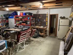 2 car garage with workbench and refrigerator.