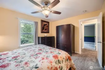 second floor bedroom on back side of house with window looking down into yard onto deck with a walk in closet and ceiling fan