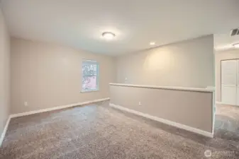 Large loft area at the top of stairs on right the hall leading to the laundry room, bathroom and additional bedrooms