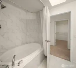 Primary bath with soaking tub across from walk-in closet.