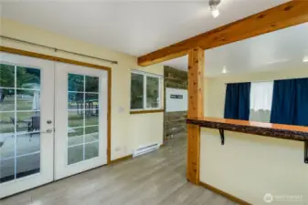 Light-toned flooring enhances the spacious feel, and a French door leads directly outside, extending the living space to the backyard.