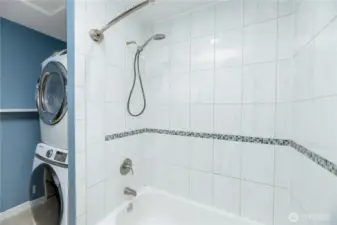 The tiled shower/tub combo includes an accent mosaic border, adding a touch of style.