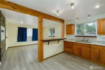 Warm wood cabinetry offers ample storage, complemented by a neutral mosaic tile backsplash and sleek marble-look countertops.