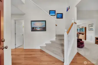 Through the front entry a grand staircase greets you.  To the right is the living room and dining room.  To the left is the door to the half bath.