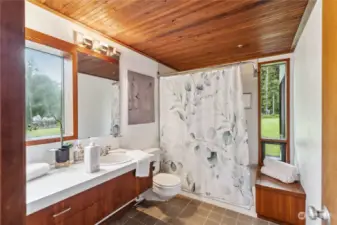 Bathroom near primary bedroom, with Klein-designed wooden ceilings and ample windows/light.