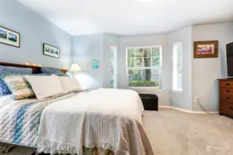 Spacious primary bedroom with light filled bay windows.