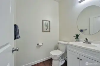 The downstairs powder room is located across the hall from the utility room.