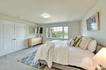 Located at the top of the stairs, you enter the primary suite through lovely double doors.