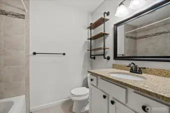 Hall bathroom with updated vanity, 12x24 tile floors and full height tile shower surround.